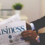 Close-up of a businessman reading a newspaper indoors, focusing on business headlines. — Achieving a Swift Sale for Your Rive