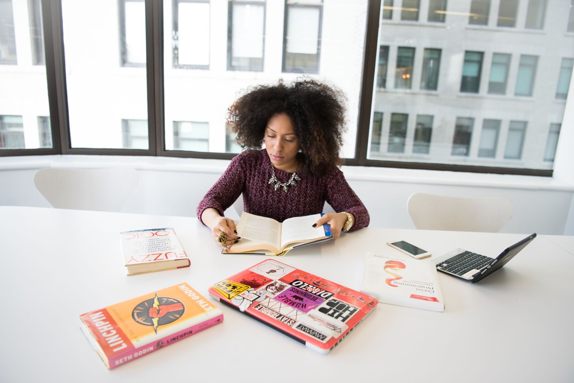 A focused woman working in an office environment, studying and reading research material. — Expert Window Installation for Ho