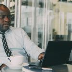Focused businessman uses laptop in stylish cafe, sipping coffee. Perfect for business or lifestyle themes. — How to Keep Your