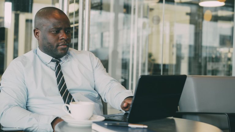 Focused businessman uses laptop in stylish cafe, sipping coffee. Perfect for business or lifestyle themes. — How to Keep Your