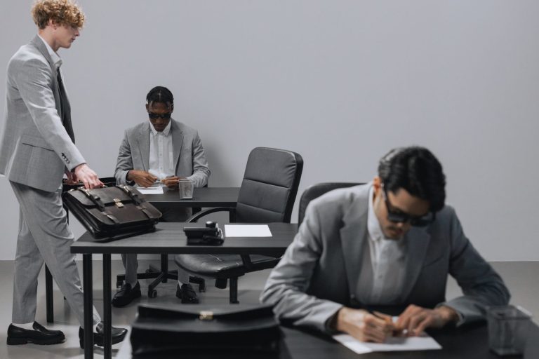 Business office with diverse employees in gray suits working at desks in an indoor setting. — The Value of Locksmith Services
