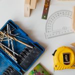 A selection of carpentry tools including drill bits, measuring tape, and protractor in an overhead shot. — What Should I Look