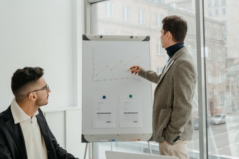 Two professionals examining graphs during an office presentation. — What To Consider Before Using The Stuart Piltch machine l